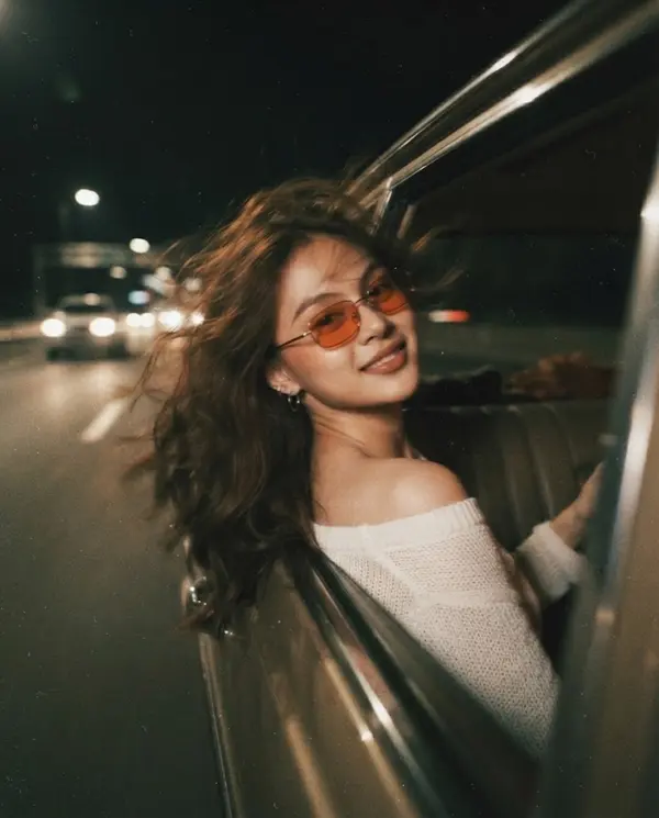 Woman leaning from car window vintage night