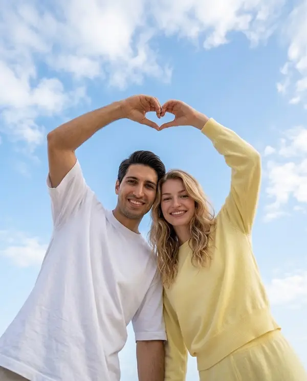 Couple Heart Pose Against Blue Sky